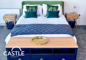 a bedroom with a large bed with blue and green pillows at Ultimate Retreat 2 houses 2 Hot Tubs Double Fun in Cayton