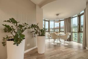 uma sala de jantar com mesa, cadeiras e plantas em Apartamenty MUNN 5 Szczecin - Golden em Szczecin