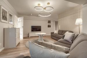 - un salon avec un canapé et une télévision dans l'établissement Apartamenty MUNN 5 Szczecin - Golden, à Szczecin