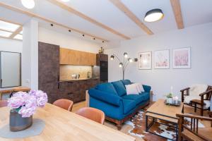 a living room with a blue couch and a table at Memel Townhouse apartamentai in Klaipėda