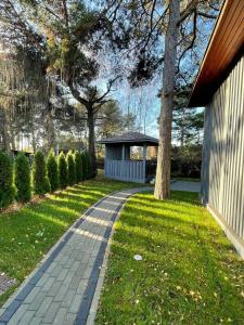 a walkway leading to a gazebo in a yard at Piejūras māja skandināvu stilā! Seaside scandi house! in Lapmežciems