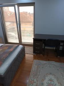 - une chambre avec un bureau et un lit dans l'établissement Apartman Anna, à Kragujevac