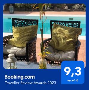 deux chaises avec des oreillers assis à côté d'une piscine dans l'établissement Villa Tabaiba Playa Blanca Lanzarote, à Playa Blanca