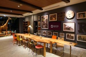 a dining room with a long table and a clock on a wall at La'gent Stay Sapporo Odori Hokkaido in Sapporo