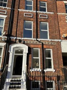 een rood bakstenen gebouw met een witte deur en ramen bij Apartment 4 - The Crescent in York