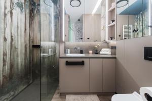 uma casa de banho com um lavatório e um chuveiro em Flisac Apartment by LoftAffair em Varsóvia