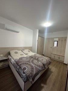 - une chambre avec un lit et une couverture à motifs dans l'établissement Къща за гости Елит (Guest House Elite), à Sapareva Banya