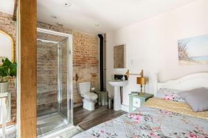 een slaapkamer met een bed en een badkamer met een douche bij Idyllic 2- Bedroom barn with amazing views in Cranbrook
