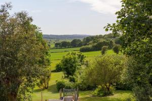 a bench in the middle of a field with trees at Idyllic 2- Bedroom barn with amazing views in Cranbrook