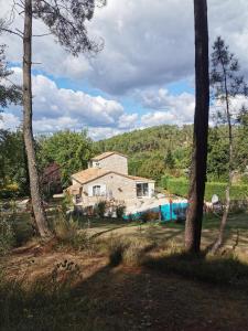 a house in the middle of a yard with trees at DOMAINE DES 3 CYPRÈS Chambre PIVOINE Chez Nath & Pat in Fumel +2 photos