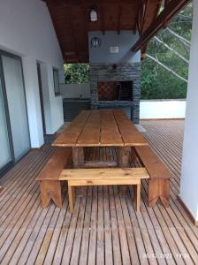 einen Picknicktisch auf einer Terrasse mit Kamin in der Unterkunft Cabañas LOS BEDUINOS in Mar de las Pampas