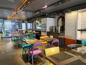 イスタンブールにあるTulip City Hotelのカラフルなテーブルと椅子が備わるレストランを併設しています。