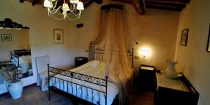 1 dormitorio con cama y lámpara de araña en Molino di Bombi, en Castellina in Chianti