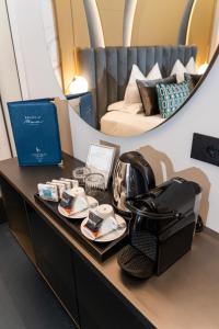 Relais sul Mare Boutique Hotel في نابولي: طاولة مع خوذة وأطباق وسرير
