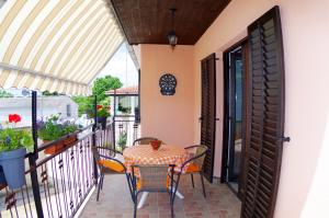 a patio with a table and chairs on a balcony at Apartment Elena, village Peresiji in Peresiji