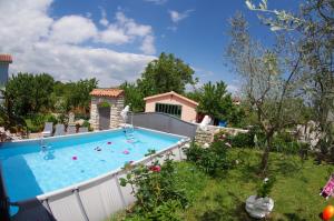 a large swimming pool in a yard with a house at Apartment Elena, village Peresiji in Peresiji