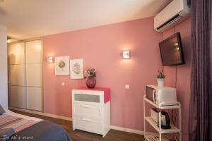 ベナルマデナにあるBeach Studioのピンクの壁のベッドルーム(テレビ付)