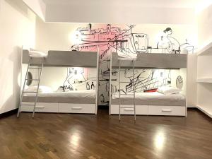 バーリにあるBARI ROOMS Abate Gimmaの壁画のあるドミトリールームの二段ベッド2台