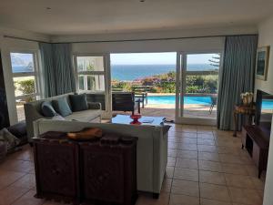 a living room with a couch and a view of the ocean at Neptunes Seat - Garden Paradise with Ocean Views in Cape Town