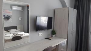 a bedroom with a bed and a tv on the wall at Laguna in Kiten