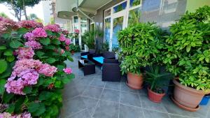 a patio with plants and flowers in pots at Laguna in Kiten