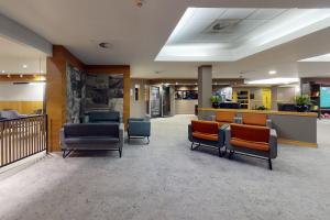 a waiting area in a hospital with chairs and tables at Village Hotel Hull in Hull