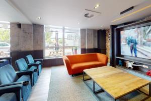 a waiting room with an orange couch and chairs at Village Hotel Hull in Hull