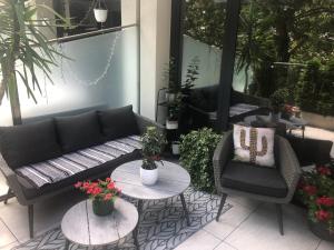 a patio with a couch and two tables and plants at Sea Garden Apartment in Varna City