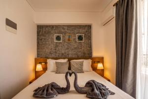 twee zwanen handdoeken op een bed in een slaapkamer bij Li Mango in Tigaki