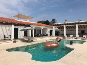 uma piscina com uma estátua de um cisne na água em Villa Maravilla with HEATABLE pool ROOFTOPbar with sea views and Range Rover em Binibeca