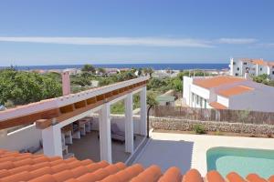 uma varanda de uma casa com vista para o oceano em Villa Maravilla with HEATABLE pool ROOFTOPbar with sea views and Range Rover em Binibeca