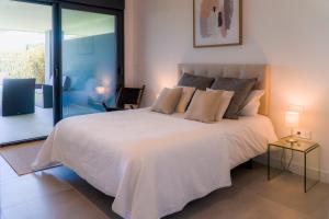 sypialnia z dużym białym łóżkiem i szklanymi drzwiami w obiekcie Wild Paradise in Costa del Sol w mieście Estepona +29 zdjęć