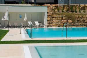 duży basen z krzesłami i parasolami w obiekcie Wild Paradise in Costa del Sol w mieście Estepona