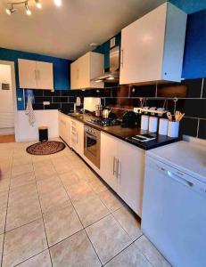 a kitchen with white cabinets and a tile floor at Joli duplex cocooning de 100m2 avec Rez de jardin in Feyzin