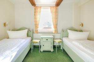 two beds in a small room with a window at Ferienwohnungen am Markt in Wernigerode
