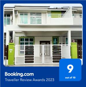 a picture of a house with a blue and white fence at Green Homestay Tangga Batu in Tangga Batu