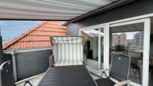un balcón con 2 sillas y una puerta en una casa en Wohnung Maren, en Sankt Peter-Ording