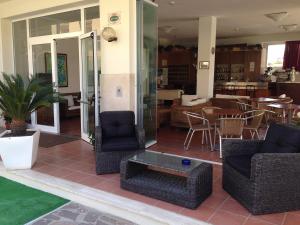 a patio with chairs and a table and a restaurant at Hotel Lima in Lido di Savio