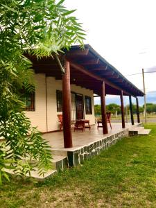 a house with a porch with a picnic table on it at LA CABAÑA in Termas de Río Hondo