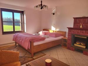 a bedroom with a bed and a fireplace at Penzion Kostelany 