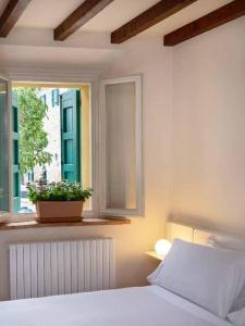 a bedroom with a bed and a window with a plant at Borgo BiancoMatilde - Boutique Hotel in Casina +4 photos