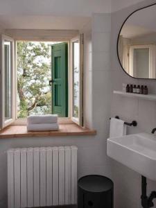 La salle de bains est pourvue d'une fenêtre, d'un lavabo et d'un miroir. dans l'établissement Borgo BiancoMatilde - Boutique Hotel, à Casina