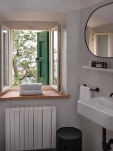 a bathroom with a window and a sink and a mirror at Borgo BiancoMatilde - Boutique Hotel in Casina