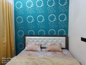 a bedroom with a bed and a blue wall at The Jay Hotel By WB Inn in Rāe Bareli