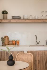 uma cozinha com um lavatório e uma mesa com cadeiras em 360ᵒ Residences em Khelmáta