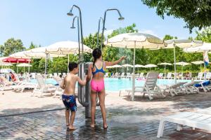 a woman and a child standing in the water at a pool at hu Roma Camping In Town in Rome