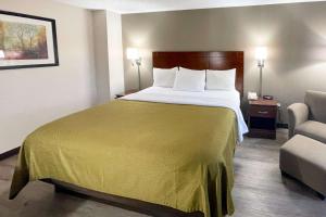 una habitación de hotel con una cama grande y una silla en Econo Lodge Cartersville-Emerson Lake Point, en Cartersville
