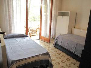 um quarto com 2 camas e uma porta para um pátio em Breathtaking seaview in Grado - Beahost Rentals em Lido