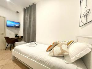 a bedroom with a white bed with a television on the wall at BARI ROOMS Abate Gimma in Bari