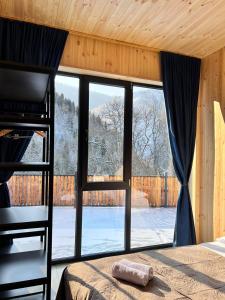 a bedroom with a large window and a bed at Cottage Orcs in Borjomi